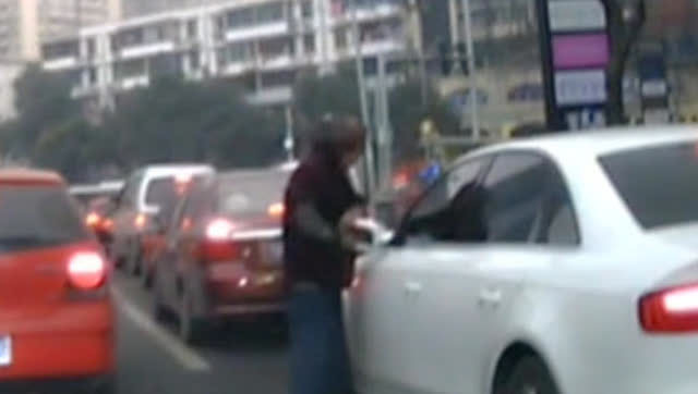 实拍男子当街拦车要钱 做一动作女司机险吓哭